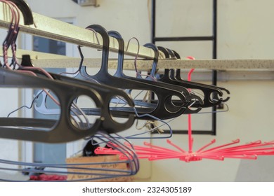 black plastic clothes hangers and wire hangers hanging in the shared clothesline, the drying area in the rented house - Powered by Shutterstock