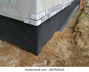 Black plastic drainage membrane fixed on the foundation of house under construction