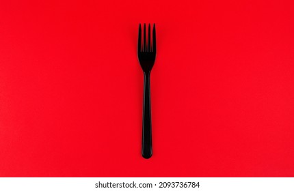 Black Plastic Fork On Red Background