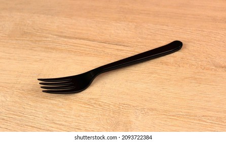 Black Plastic Fork On Wooden Background