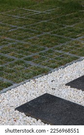 black plastic grid with green grass for the cars and white decorative stones for the path - Shutterstock ID 2256968551