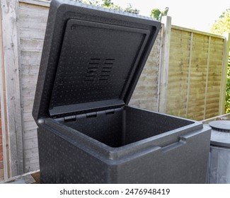 Black Plastic Hot Bin Compost Bin with Lid Open Showing Vents, in Urban Backyard