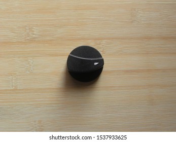 Black Plastic On Off Gas Stove Knob Kept On Wooden Table