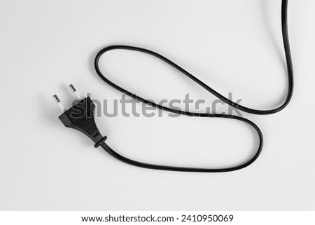 black plastic plug from an electrical appliance with a wire, isolated on a white background