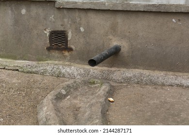 Black Plastic Rainwater Drain Pipe At The Base Of The House.