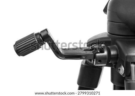 Black plastic rotating handle of an adjustable prof studio tripod closeup isolated over white