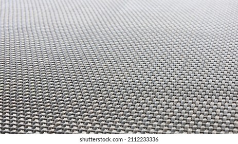 Black Plastic Woven Background. The Texture Of The Weave Rubber Material Found In Modern Outdoor Furniture. Abstract Background Concept. Selective Focus