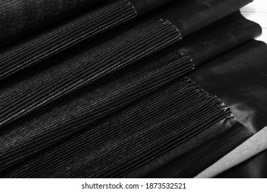 Black Pleated Leather Lining Folded On A Wooden Table