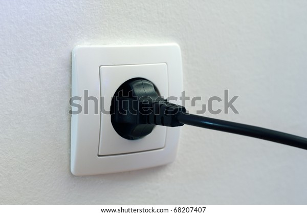 Black plug plugged in a\
socket.