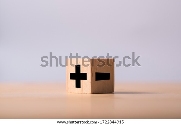 Black of plus and minus sign in opposite side of\
wooden cube.