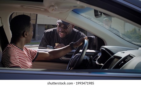 Black Policeman Checking Documents Of Driver