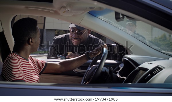 Black policeman
checking documents of
driver