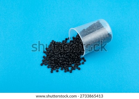 Black polyethylene granules or masterbatch. Plastic recycling. Granulated plastic polymer colored with carbon black pigment.