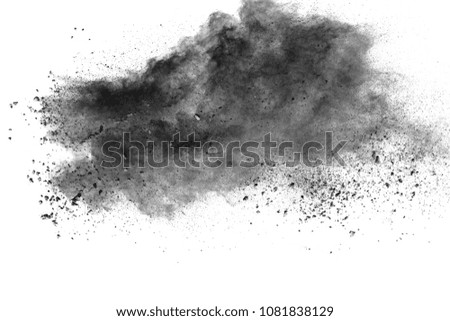 Black powder explosion against white background.The particles of charcoal splattered on white background. Closeup of black dust particles explode isolated on white background.