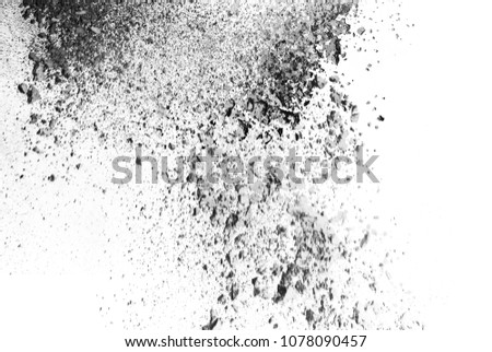 Black powder explosion. Closeup of black dust particles explode isolated on white background. 