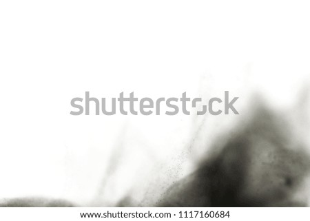  Black powder explosion. Closeup of black dust particles explode isolated on white background. 