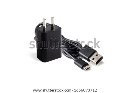 Black power adapter with USB cable for charging smartphones on a white background. USB cable with standard A and micro-USB standard B connectors for connecting smartphones to PC and other devices. Stock photo © 