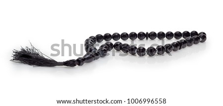 Black prayer beads with 33 knots made of stone on a matte surface on a white background
