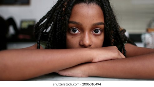 Black preteen girl eyes staring at camera. Adolescent teen face close-up