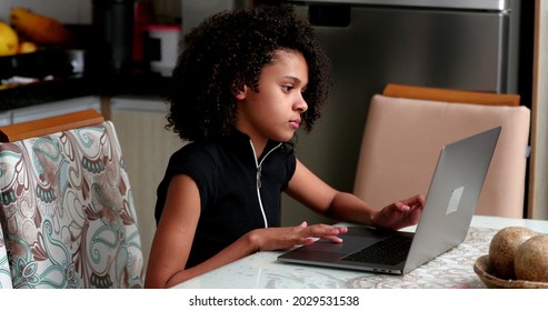 Black Preteen Girl Using Laptop At Kitchen. Child Browsing Internet