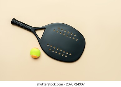 Black professional beach tennis racket and ball on beige background. Horizontal sport theme poster, greeting cards, headers, website and app