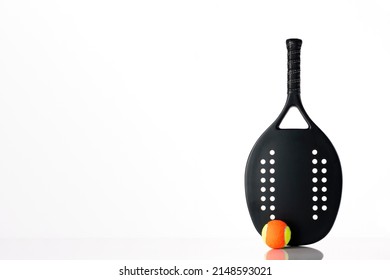 Black professional beach tennis racket and ball on white background. Horizontal sport theme poster, greeting cards, headers, website and app