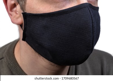 Black Protective Fabric Mask With Rubber Bands Wearing On A Face Close-up 
