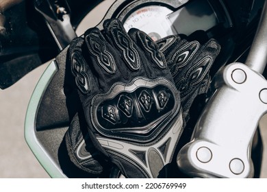 Black protective gloves for a motobiker with plastic inserts.