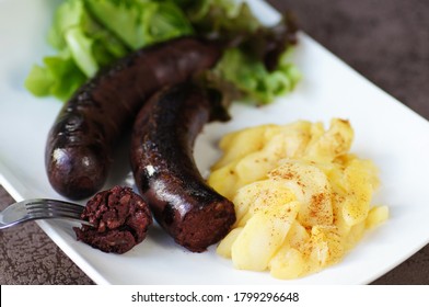 black pudding with caramelized apple on a design white plate