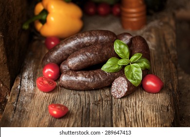 Black pudding, with cut slices, on chopping board over stone background. Krupniok really Polish black pudding.