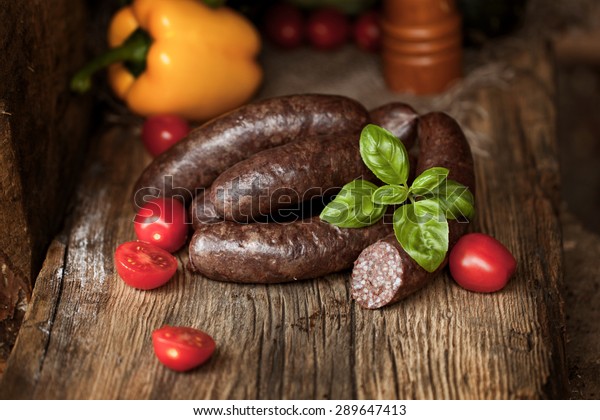 Black pudding, with\
cut slices, on chopping board over stone background. Krupniok\
really Polish black\
pudding.