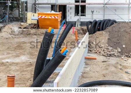 Black PVC flexible corrugated plastic insulation pipes tubing of electrical cables wire at undeground installation. New modern building construction site with engineering pipeline drainage technology