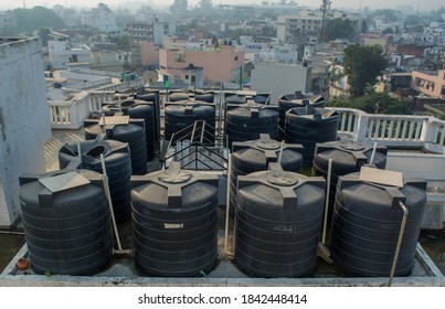 Black PVC water storage tanks kept in an arrangement on a roof 