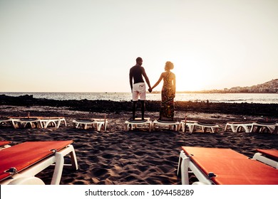 Black Race African American Couple Having Fun And Joking Playing Together On The Walk Near The Beach. Vacation Happiness Concept For Two Beautiful Young Man And Woman