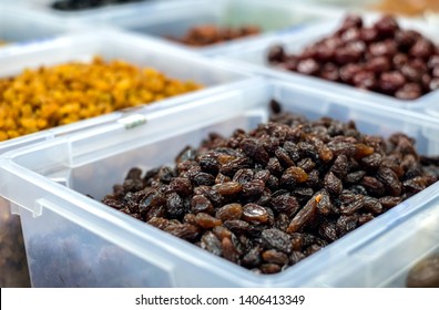 Black Raisin In Big White Box With Yellow Raisin And Brown Fruit Behind In Market Ambient