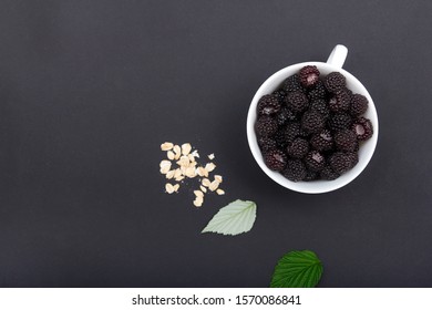 Black raspberries in a white mug on a black background Smoothies