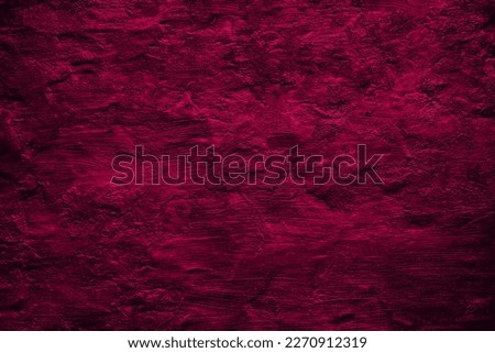 Black raspberry red rough painted surface. Toned old wall. Viva magenta color. Trend 2023. Close-up. Dark colorful grunge texture background for design. Brush strokes. Distressed, dirty, grain.