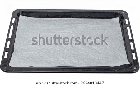 A black rectangular baking sheet lined with a sheet of baking parchment paper, ready for baking. Clean and empty, prepared for oven use.