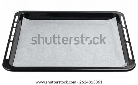 A black rectangular baking sheet is shown, lined with a piece of parchment paper. The sheet is empty and ready for baking. Its a standard kitchen item.