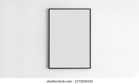 Black rectangular picture frame on white wall with blank paper in it. You can place your image in this frame. Interior photo. Painting, poster, photograph. Decorate your apartment in a modern style