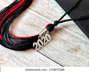 Black And Red 2020 Graduation Cap With Tassel On A Wooden Background