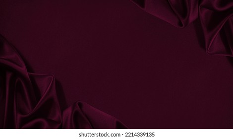 Black red burgundy silk satin. Soft wavy folds. Shiny fabric. Dark cherry luxury background with space for design. Christmas, Birthday, Valentine. Elegant, rich, chic, fancy. Flat lay, table top view. Stock Photo