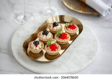 Black And Red Caviar Tartlets On Gold Plate