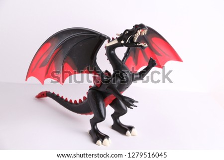 black and red dragon toy on white background
