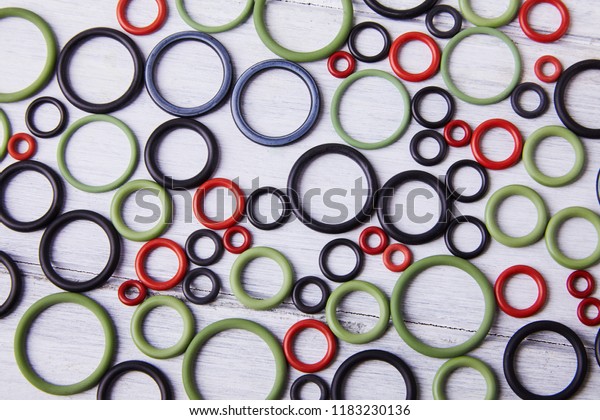 Black, red and gre hydraulic and pneumatic o-ring\
seals of different sizes scattered a white background. Rubber\
rings. Sealing gaskets for hydraulic joints. Rubber sealing rings\
for plumbing. Top view