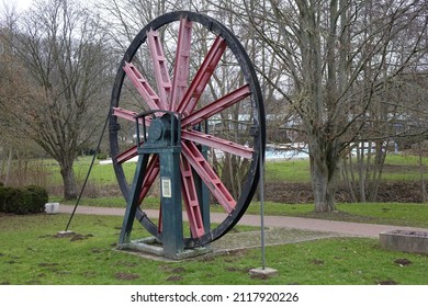 Black, red and green metal wheel with steel cable, originally used in a salt mine's winding tower (horizontal), Bad Salzdetfurth, Lower Saxony, Germany