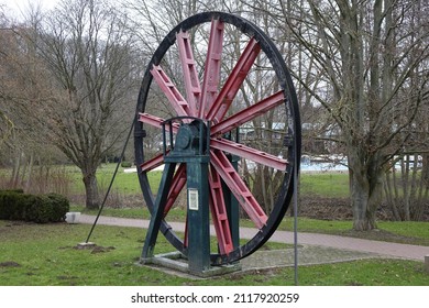 Black, red and green metal wheel with steel cable, originally used in a salt mine's winding tower (horizontal), Bad Salzdetfurth, Lower Saxony, Germany
