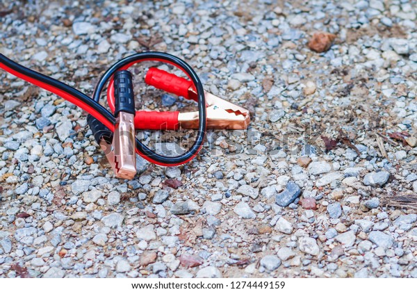 The black and red jumper wires used to stimulate the\
car battery are placed on the ground to prepare for the car battery\
jumper.\
Concepts of learning and solving problems of non-stick\
cars