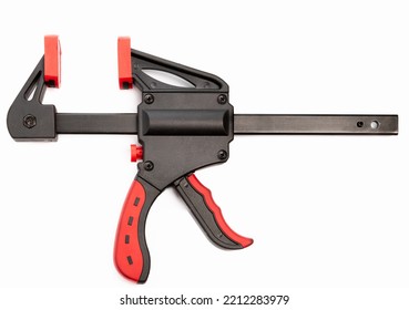 Black And Red Plastic And Metal Bar Clamp Isolated On White Background Closeup. Clamping Equipment. 