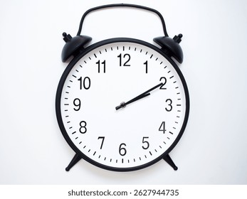 Black Retro Alarm Clock Showing 02:10 or 14:10. Classic Bell Style on White Wood Background.